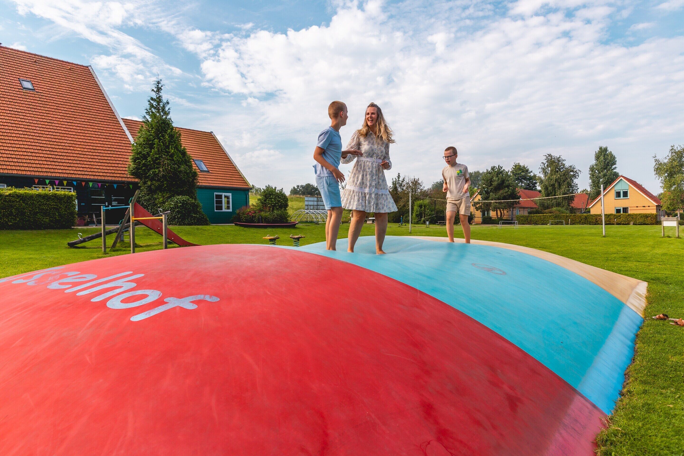 A large inflatable slide in a residential area with houses in the background.