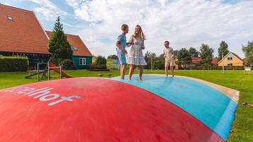 A large inflatable slide in a residential area with houses in the background.