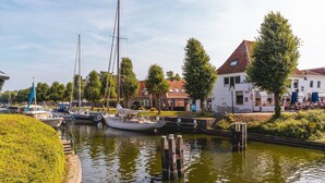 Un canal con barcos amarrados, rodeado de edificios y árboles.