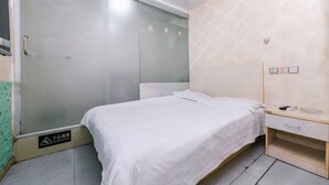 A bedroom with a bed, a wardrobe, and a bedside table. - Changlai Hostel (Shanghai)