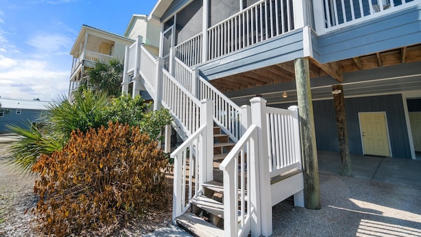 A two-story building with a white staircase and balcony railings. - Beach House - Hooked on the Cape by PHG (Port St. Joe)