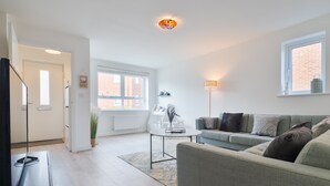 Un salon moderne avec un canapé, une table basse et un meuble pour la télévision.