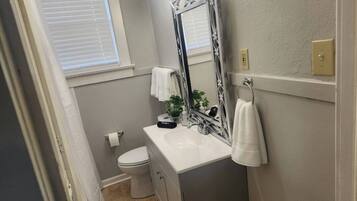 Un bagno con un lavandino bianco, un water e uno specchio grande con cornice decorativa.