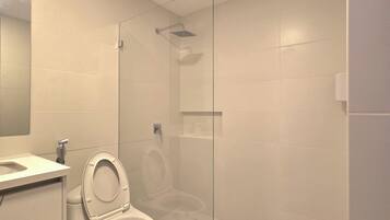 Une salle de bain moderne avec des toilettes, une douche à parois de verre et un sol en marbre.