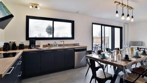 A modern kitchen with a large window, built-in appliances, and a dining area set for six.