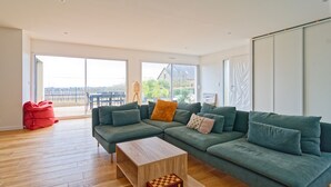 A modern living room with a sectional sofa, a wooden coffee table, and a red bean bag.
