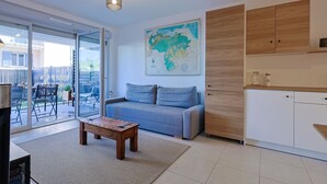 A modern living room with a sofa, coffee table, and a map on the wall. - Casa Kenez - A 5min de la plage (Cavalaire-sur-Mer)