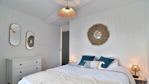 A bedroom with a bed, bedside tables, a dresser, and wall decorations.