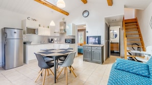 Una cocina moderna con comedor, sofá y escalera.
