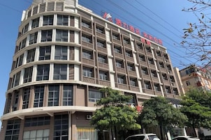 Un hotel de varios pisos con fachada curva, amplias ventanas y un cartel que indica que es un hotel.