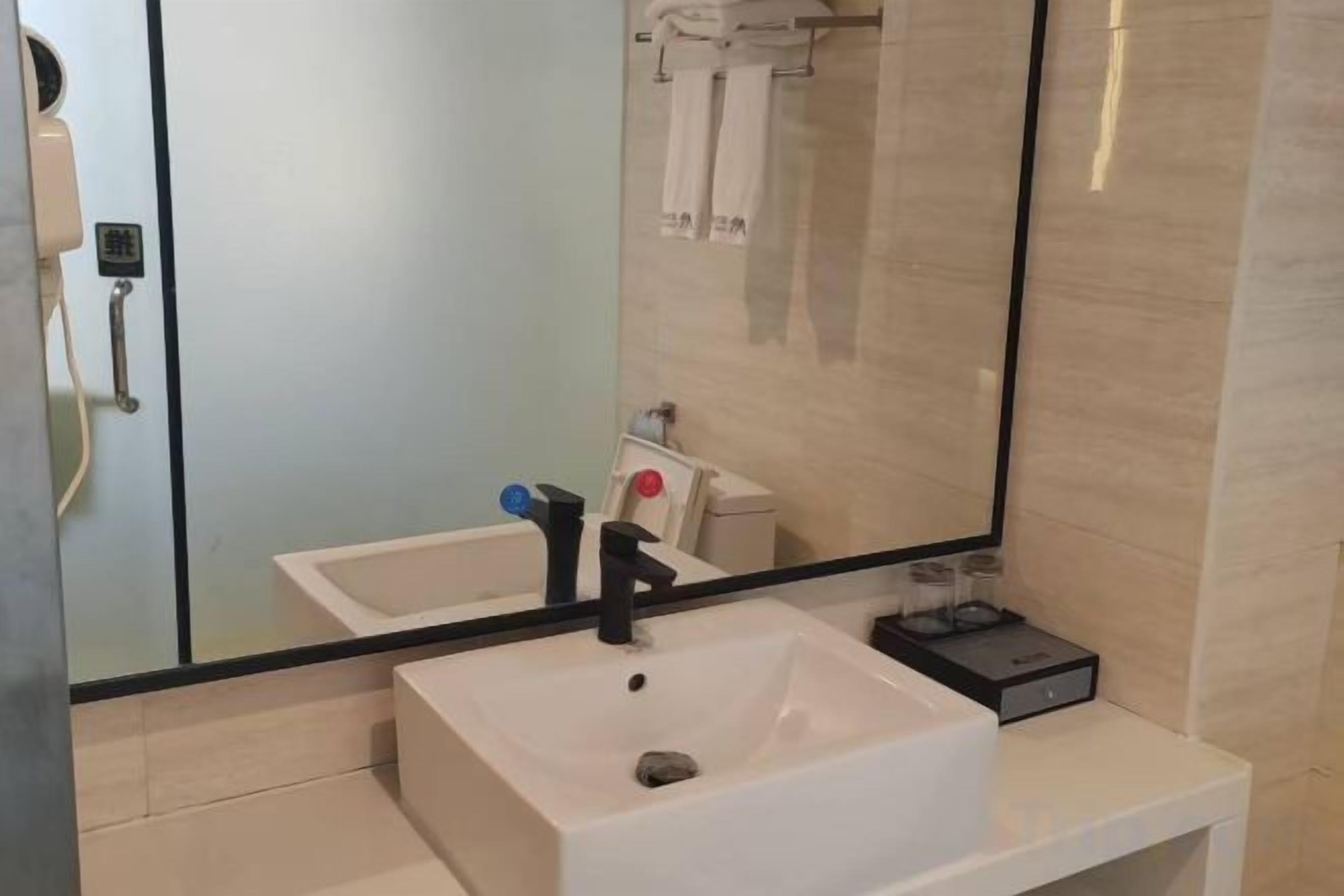 A bathroom with a white sink, a mirror, and a glass shower enclosure.