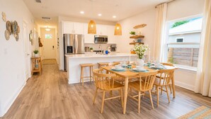 A modern kitchen with white cabinets, stainless steel appliances, and a central island. - Family Retreat - Arcade, Fire Pit, Game Room, King Bed - 2 mi Downtown! (St. Augustine)