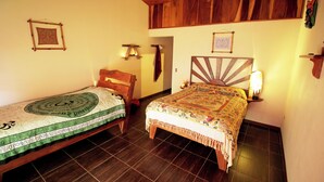Una habitación con dos camas de madera, techo de madera y suelo de baldosas.