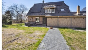 Ein zweistöckiges Haus mit Ziegelverkleidung, einem Ziegeldach und einem gepflasterten Weg zum Eingang.