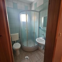 Chuveiro, toalhas de banho, sabonete, shampoo