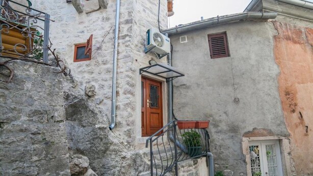 A narrow stone staircase leading to a wooden door with a small balcony. - Cozy Stay in Kotor’s Old Town - Studio Apartment (Kotor)