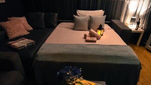 A neatly arranged bedroom with a bed, bedside tables, and a nightstand.
