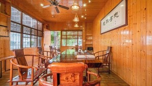 A wooden interior with a long table and chairs, ceiling fans, and large windows. - Four Seasons Hotel (Nanning Zoo Qingchuan Subway Station) (Nanning)