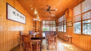 A wooden interior with a dining area, ceiling fan, and large windows. - Four Seasons Hotel (Nanning Zoo Qingchuan Subway Station) (Nanning)