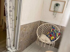 Relax in a cozy corner with a hanging chair and a touch of greenery.