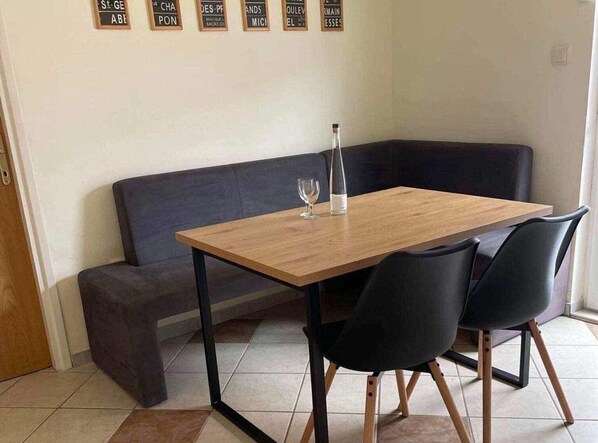 Enjoy meals and social gatherings in this cozy dining area with a table, chairs, and comfortable sofa.