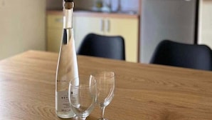 Eine Flasche und zwei Gläser auf einem Holztisch in einer Küche.