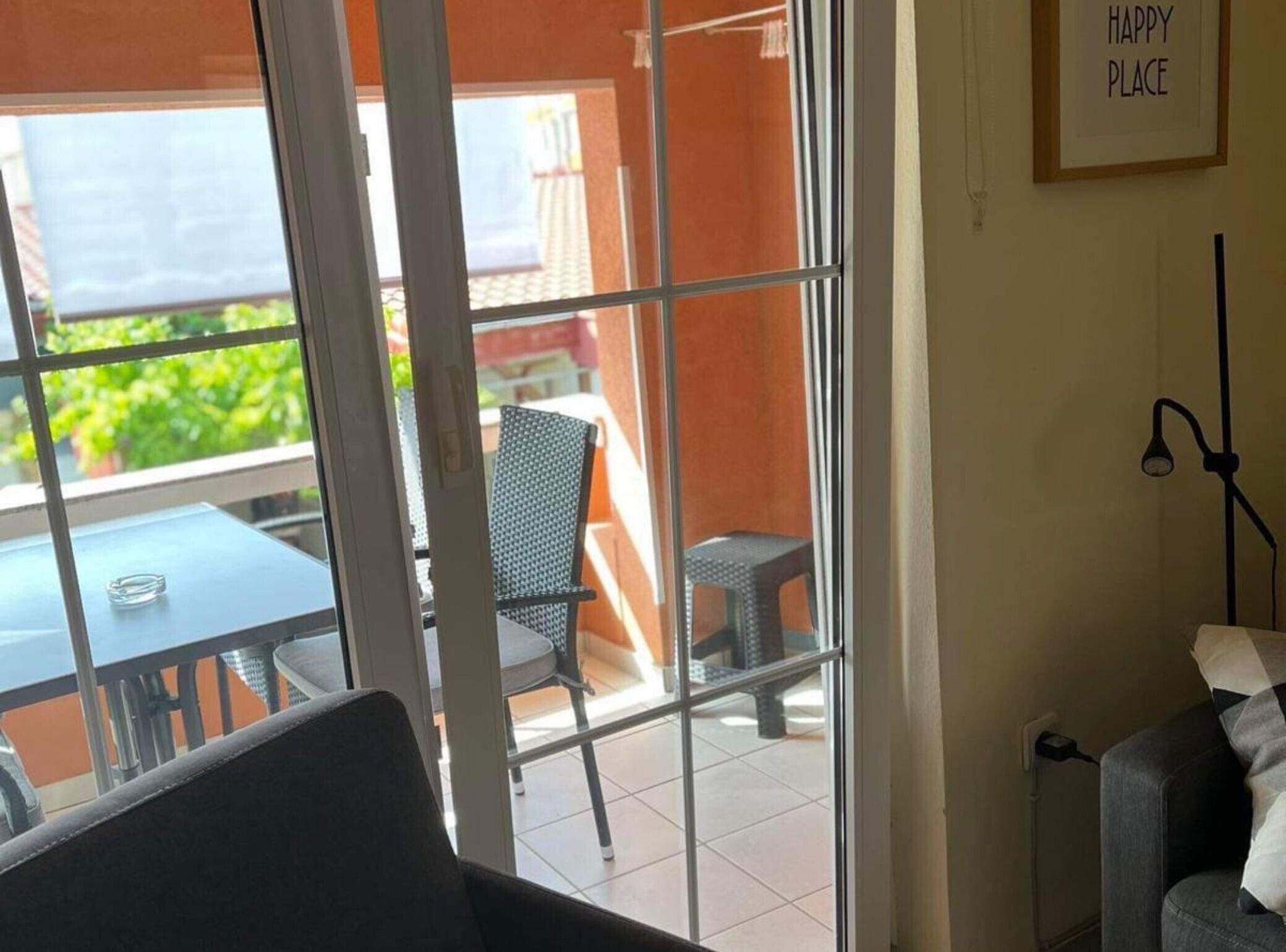 A room with a sliding glass door leading to an outdoor area with a table and chairs.