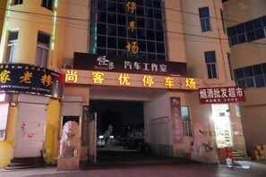 A building entrance with a sign for a car service station and a car dealership. - Shankee Hotel (Fei County) (Fei County)