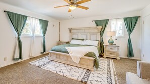 A bedroom with a bed, a nightstand, a lamp, a ceiling fan, and a window with curtains. - 9 Mi to Dtwn: Spacious Retreat in Corpus Christi! (Corpus Christi)