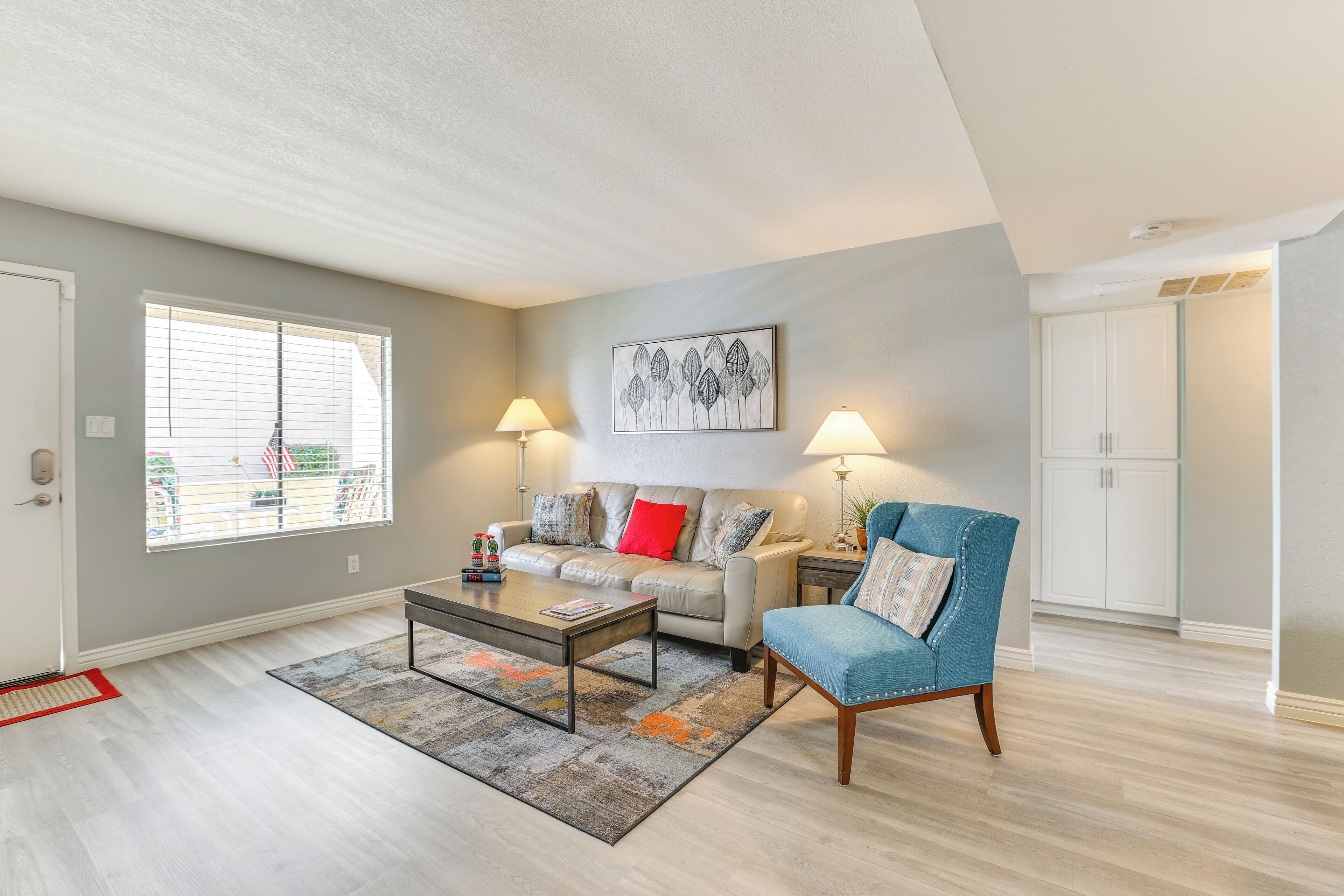Un salon comprenant un canapé, un fauteuil, une table basse et des lampes.