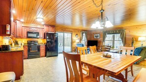 L’intérieur d’une cabane en bois comprend une cuisine, un coin repas et un salon.