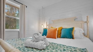 A neatly made bed with a patterned bedspread, a wooden headboard, and colorful pillows. - Island Oasis, Pool+Hot Tub+Games (Savannah)