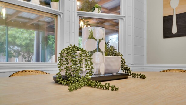 A dining area with a wooden table, white chairs, and potted plants. - Island Oasis, Pool+Hot Tub+Games (Savannah)