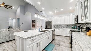 A modern kitchen with white cabinetry, a central island, and a built-in oven. - Massive Lake Views & Stunning Sunsets: Waverly Gem (Waverly)