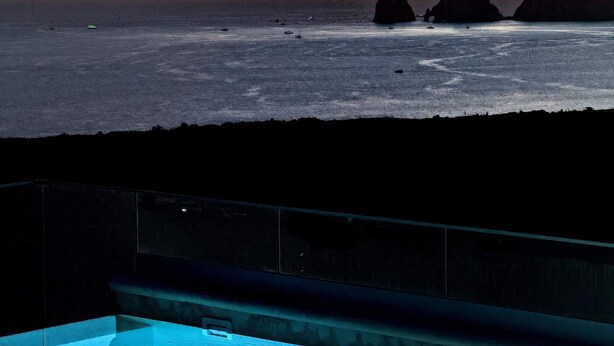 A pool with a view of the ocean and a sunset. - Rooftop Infinity Pool Condo Cabo San Lucas • Modern 2BR El Tezal | 202 (Cabo San Lucas)