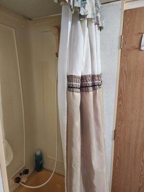 Een douche, handdoeken, zeep, toiletpapier