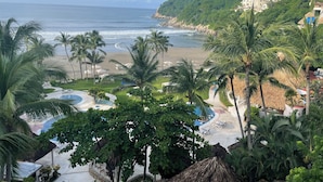 Un complexe hôtelier doté d’une piscine, d’une plage et offrant une vue sur l’océan.