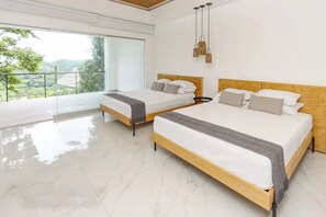 Une chambre moderne avec deux lits, de grandes fenêtres et un balcon.