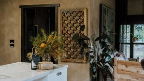 Una habitación con encimera de mármol, puerta de madera, panel decorativo en la pared y cama con cabecero de madera.