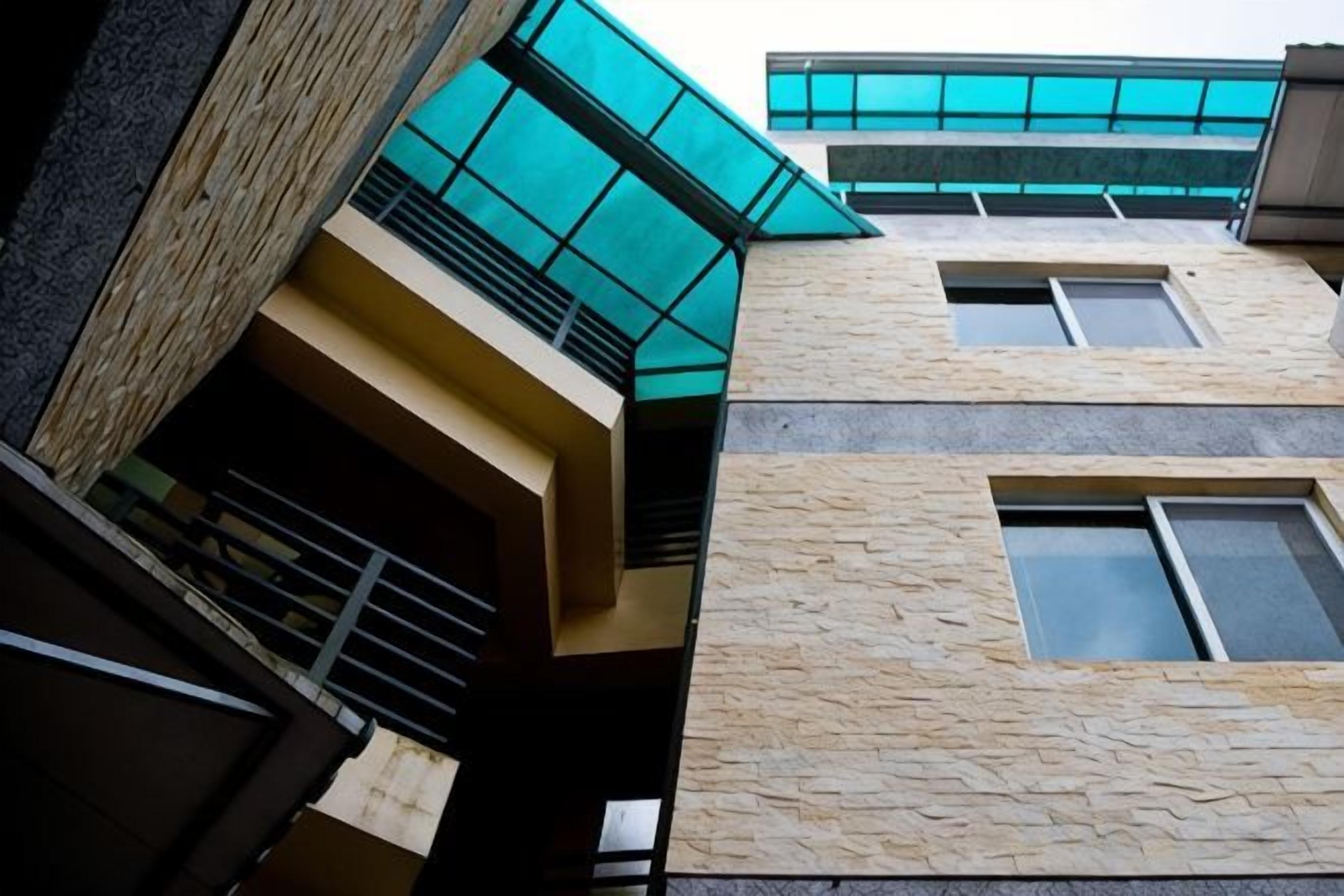 A multi-story building with a stone facade and large windows.