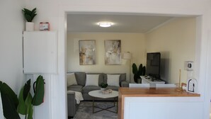 A modern living room with a sofa, coffee table, and artwork on the wall.