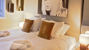 A hotel room with a neatly made bed, pillows, and a large framed artwork on the wall. - Holiday Home in Yn e Lijte With Water Sports (Grou)