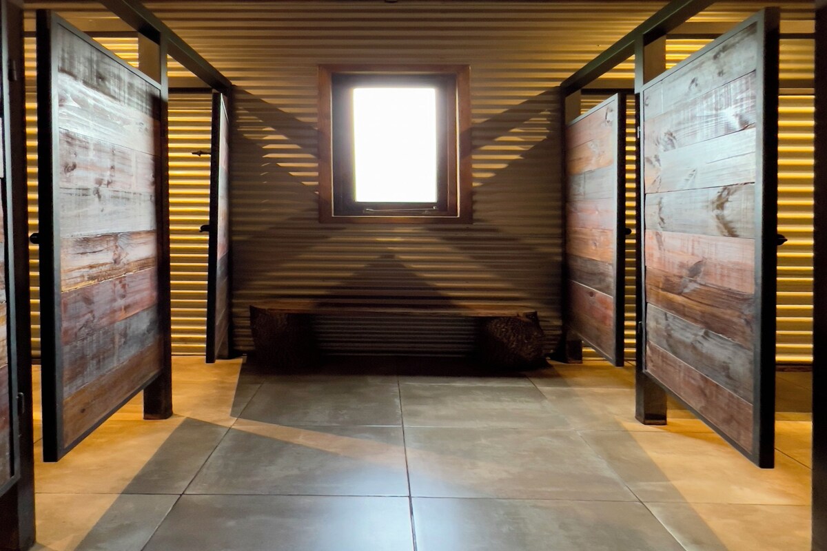 A room with a sloped ceiling, a window, and a bench.