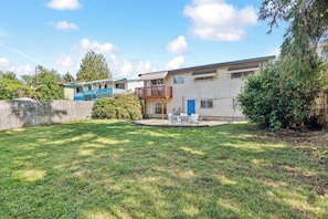 A residential property with a fenced yard, a balcony, and a blue door.