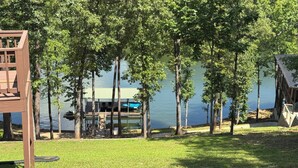 A lakeside property with a wooden deck, a swimming pool, and a covered outdoor seating area. - Serene Waterfront Lake Wedowee Home (Wedowee)