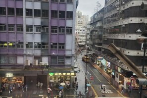 A busy urban street with buildings, shops, and pedestrians. - Wing Tai Guest House (Hong Kong)