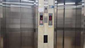 Interieur van een lift met rvs wanden en twee digitale displays die de verdiepingen 3 en 6 aangeven.