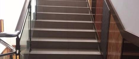 A staircase with a handrail and glass panels on the sides.