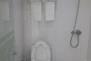A bathroom with a toilet, a shower, and two towels hanging on a rack. - Shanghai Longting Hotel (Shanghai)