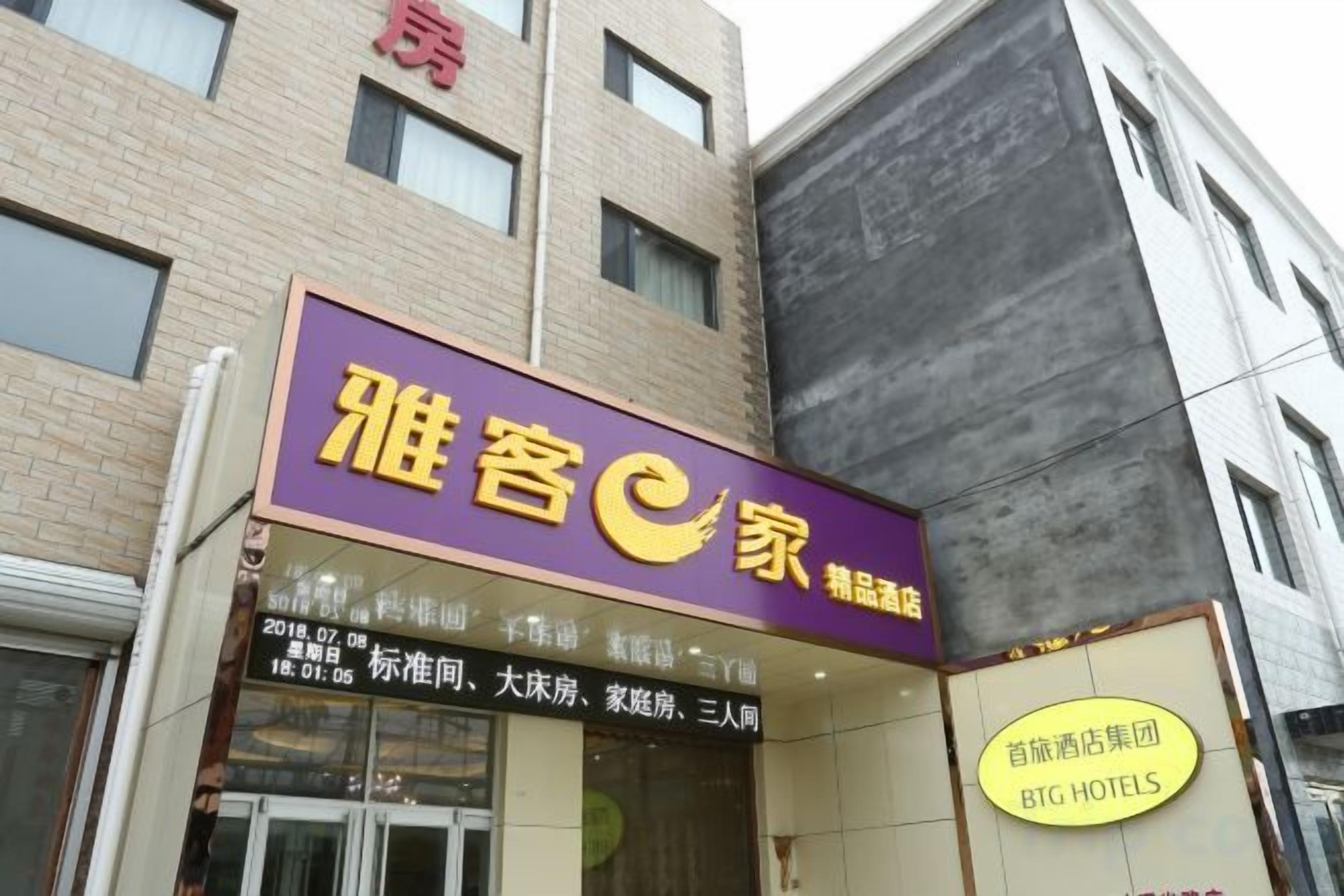 Un hotel con un letrero púrpura y un cartel amarillo que indica que pertenece a la cadena BIG HOTELS.